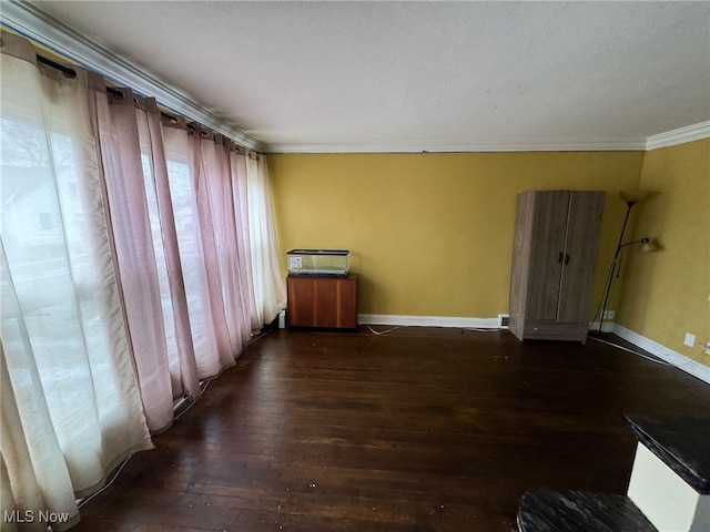 empty room with crown molding and dark wood-type flooring