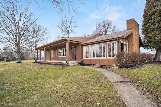 rear view of house featuring a porch and a lawn