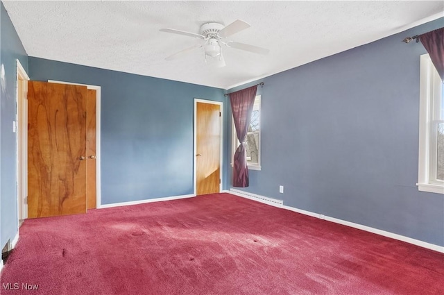 carpeted empty room with ceiling fan, a textured ceiling, and a baseboard heating unit