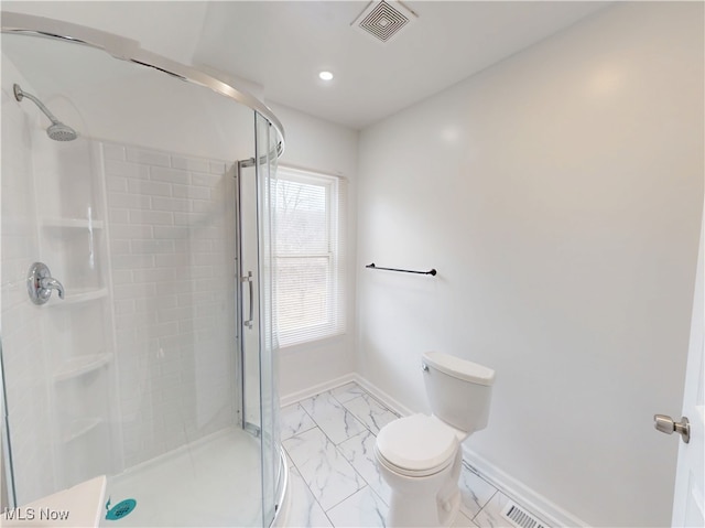 bathroom with a shower with door and toilet