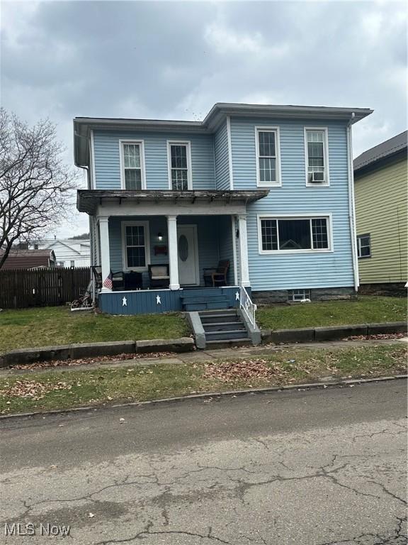 view of property featuring a porch and a front yard