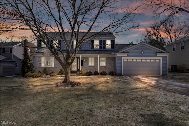 view of front of home featuring a garage and a yard