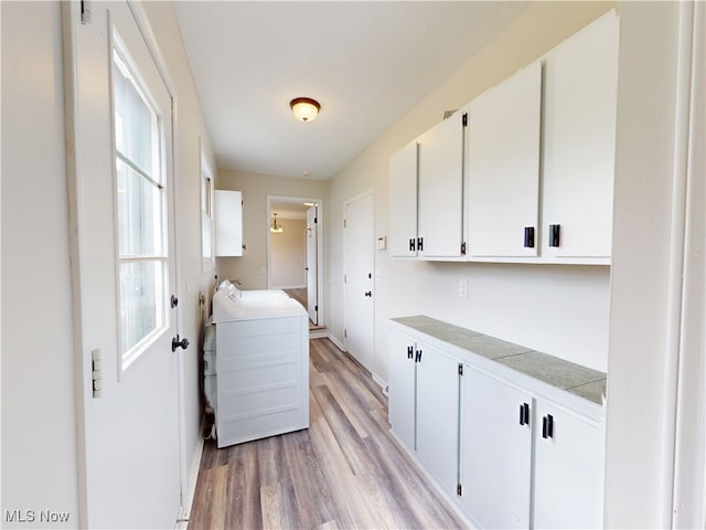 laundry area featuring cabinets, washer / dryer, and light wood-type flooring