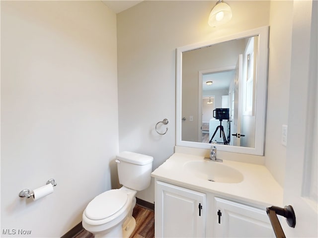 bathroom with vanity, hardwood / wood-style flooring, and toilet