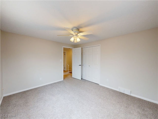 spare room with ceiling fan and carpet