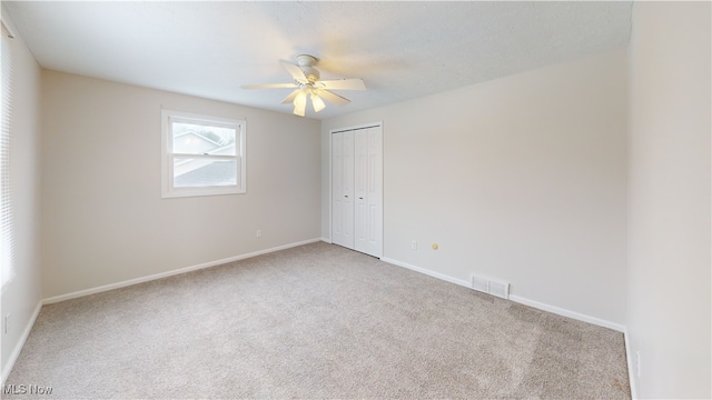 carpeted spare room featuring ceiling fan