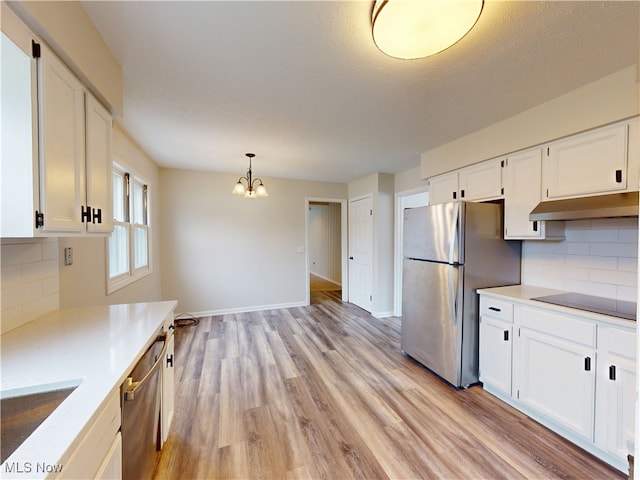 kitchen with white cabinetry, sink, hanging light fixtures, light hardwood / wood-style floors, and stainless steel appliances