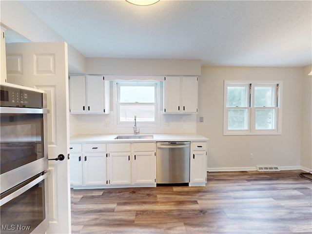 kitchen featuring stainless steel appliances, sink, and white cabinets