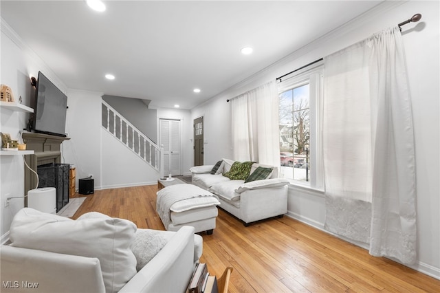 living room with ornamental molding and light hardwood / wood-style flooring