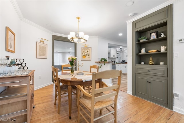 dining room featuring crown molding, an inviting chandelier, and light wood-type flooring