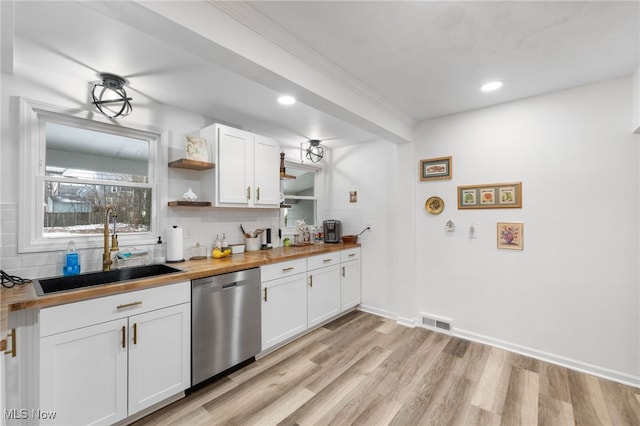 kitchen featuring sink, light hardwood / wood-style flooring, wooden counters, white cabinets, and stainless steel dishwasher