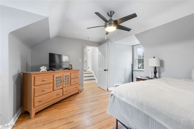 bedroom with vaulted ceiling, ceiling fan, and light hardwood / wood-style floors