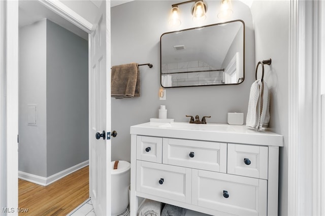 bathroom featuring vanity, hardwood / wood-style floors, and toilet