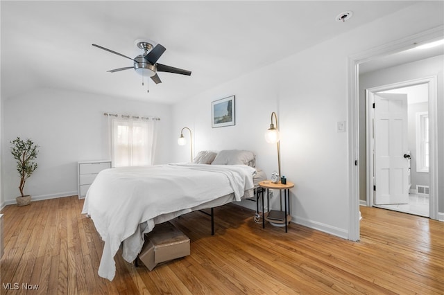 bedroom with ceiling fan, vaulted ceiling, and light hardwood / wood-style flooring