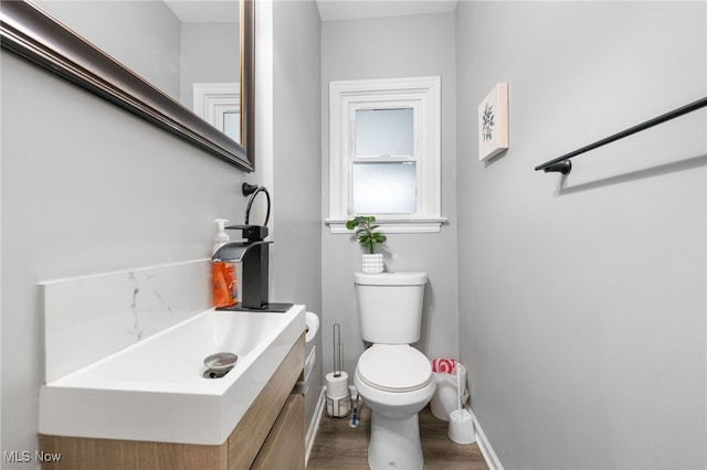 bathroom with vanity, wood-type flooring, and toilet