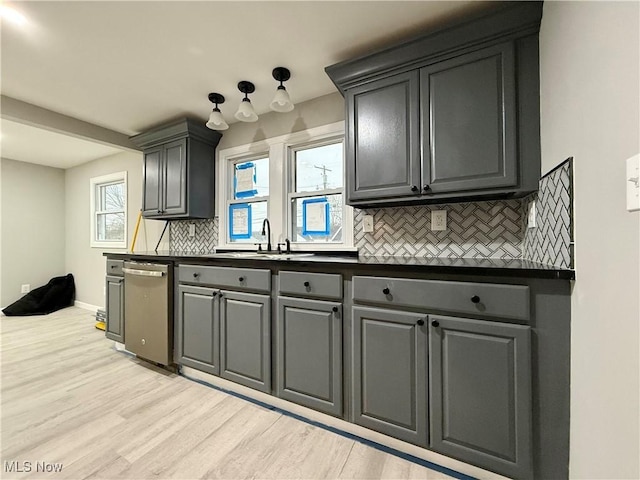 kitchen featuring gray cabinets, light wood-type flooring, sink, and backsplash