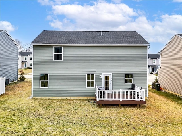 rear view of property featuring a deck and a lawn