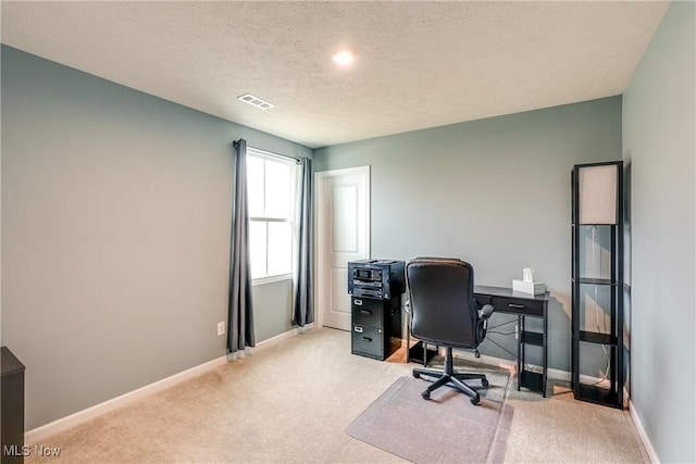 office space featuring light carpet and a textured ceiling