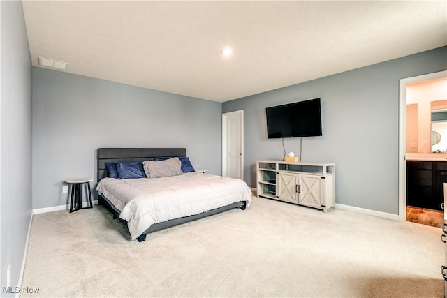 bedroom with ensuite bath and carpet floors