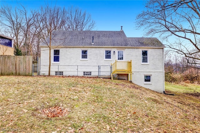 rear view of property featuring a lawn