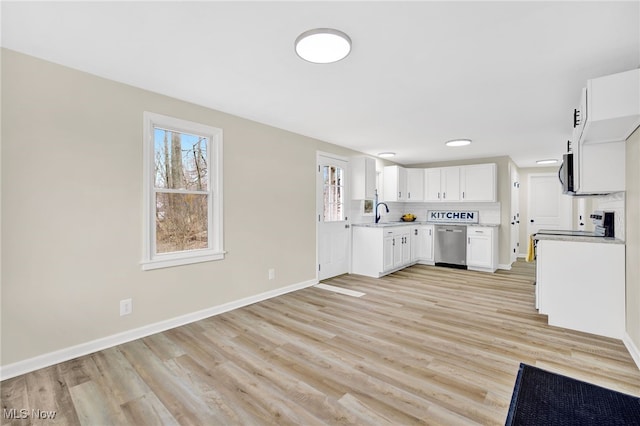 kitchen featuring white cabinetry, appliances with stainless steel finishes, a wealth of natural light, and backsplash