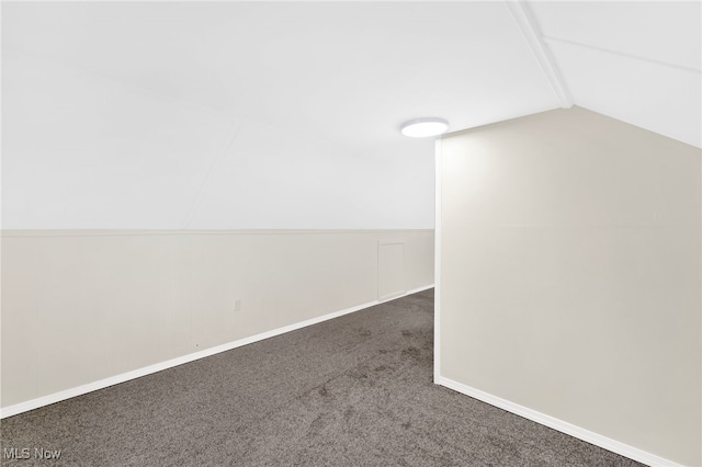 carpeted empty room with lofted ceiling