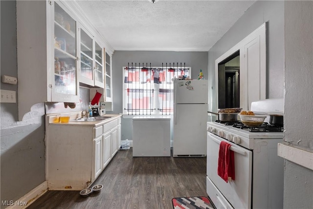 kitchen with white cabinetry, white appliances, dark hardwood / wood-style flooring, and a textured ceiling