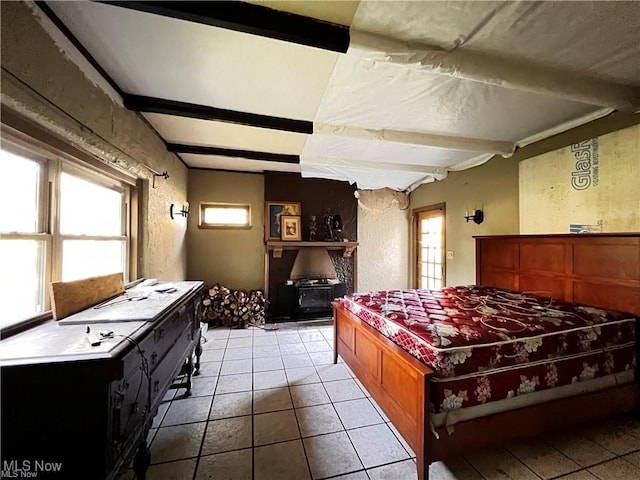 bedroom with light tile patterned flooring and beam ceiling