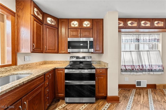 kitchen featuring light stone counters and appliances with stainless steel finishes