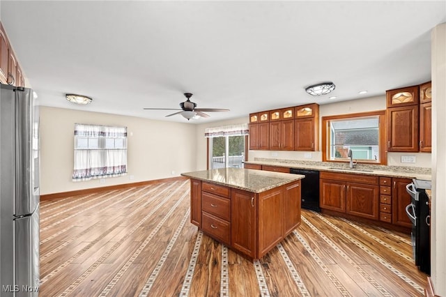 kitchen featuring range with electric stovetop, a kitchen island, stainless steel refrigerator, sink, and light hardwood / wood-style floors