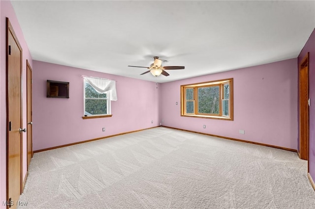 carpeted spare room featuring ceiling fan