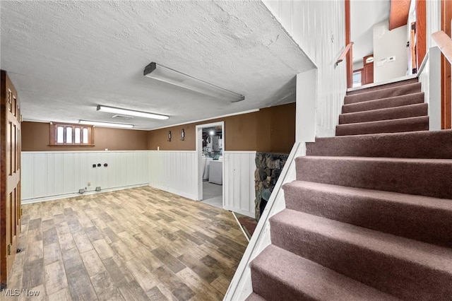 basement featuring hardwood / wood-style flooring and a textured ceiling