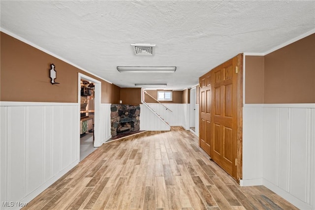 interior space featuring a textured ceiling and light hardwood / wood-style floors