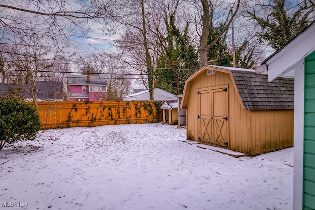 yard covered in snow with a shed