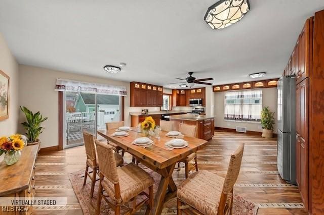 dining room with ceiling fan and light wood-type flooring