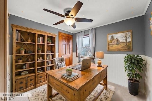 carpeted office space featuring crown molding and ceiling fan