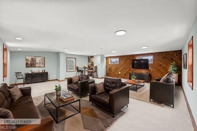 carpeted living room with wooden walls