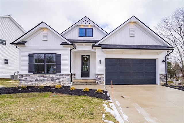 view of front of property with a garage, central AC unit, and a front lawn