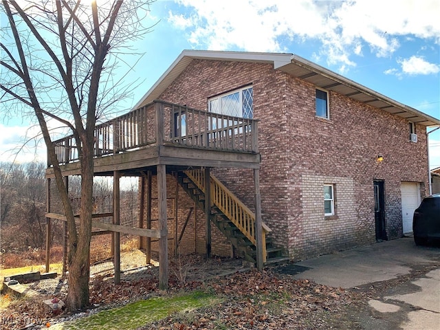 rear view of property with a garage and a deck