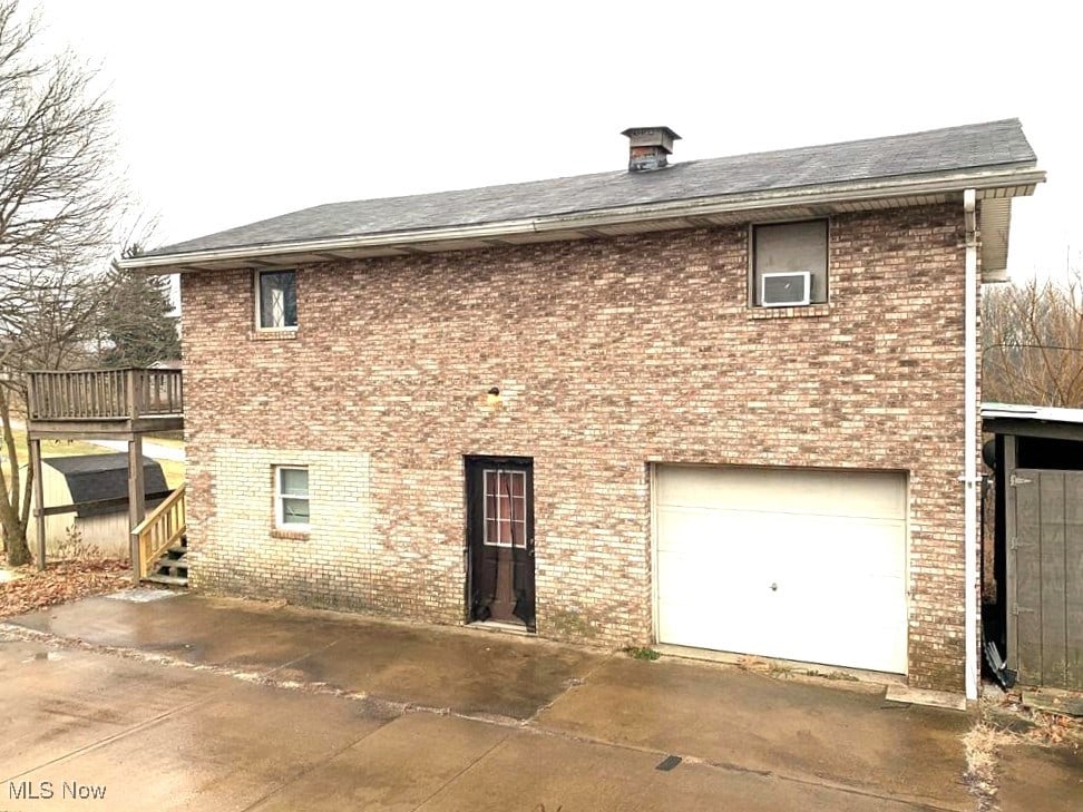 rear view of house with a garage and a deck