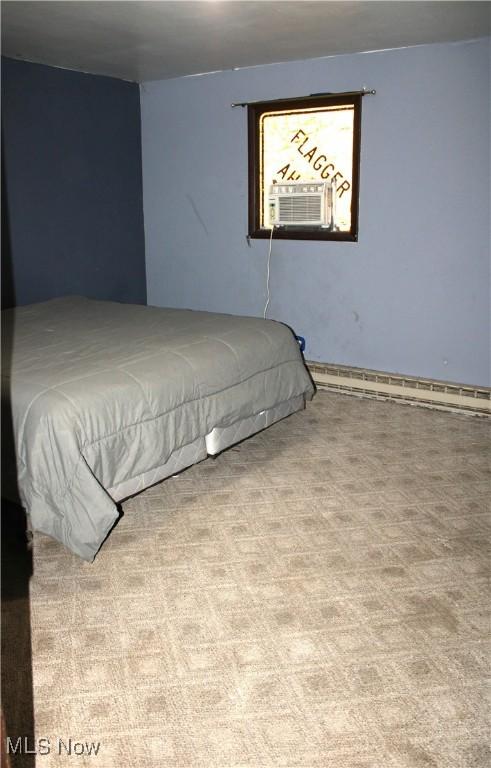 bedroom with baseboard heating, cooling unit, and light colored carpet