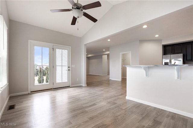 unfurnished living room featuring ceiling fan, high vaulted ceiling, and light hardwood / wood-style flooring