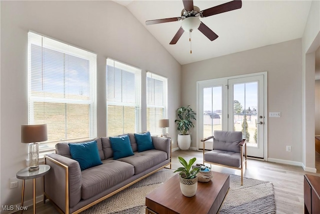 living room featuring ceiling fan, vaulted ceiling, and light hardwood / wood-style flooring