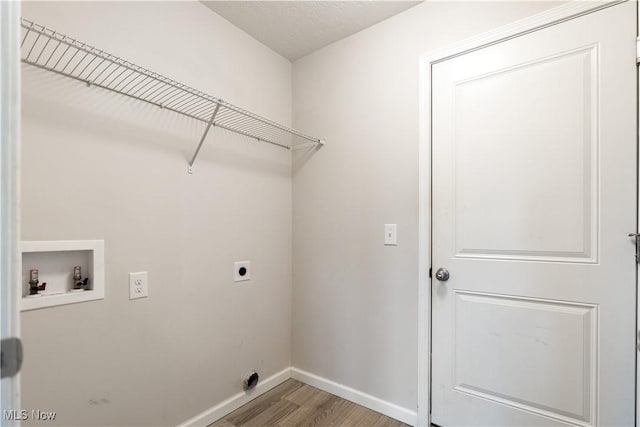 clothes washing area with hookup for an electric dryer, hookup for a washing machine, and hardwood / wood-style floors