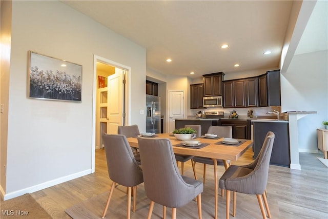 dining space featuring sink and light wood-type flooring