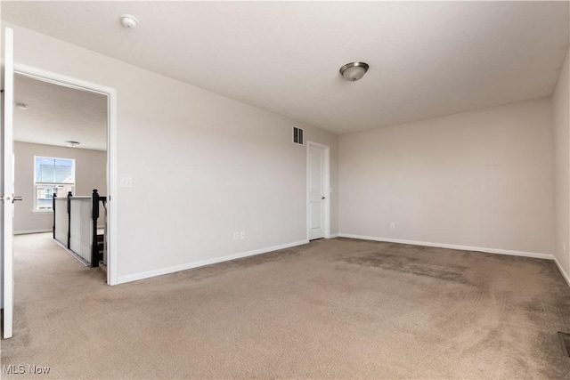 spare room featuring light colored carpet