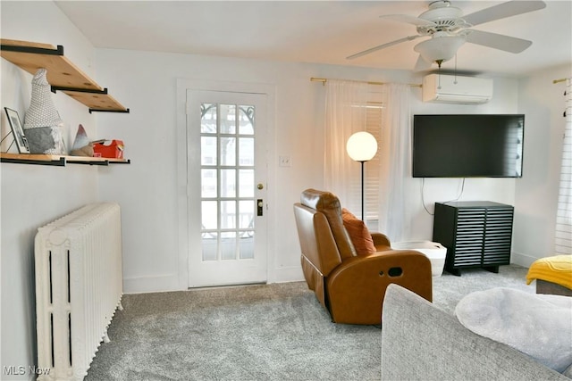 sitting room with ceiling fan, light colored carpet, radiator, and a wall unit AC