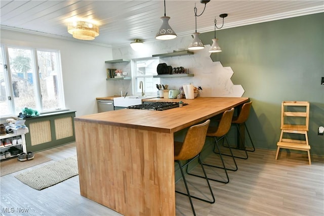 bar featuring wood counters, dishwasher, hanging light fixtures, ornamental molding, and light hardwood / wood-style flooring