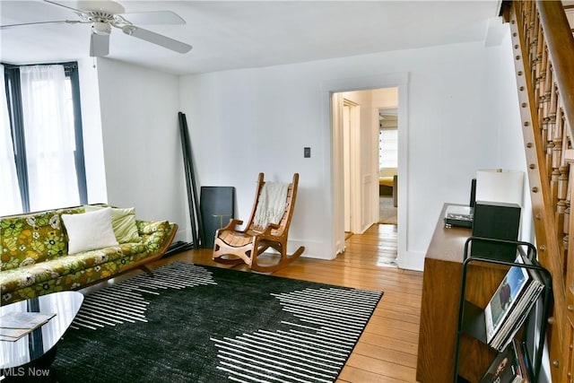 living room featuring hardwood / wood-style floors and ceiling fan