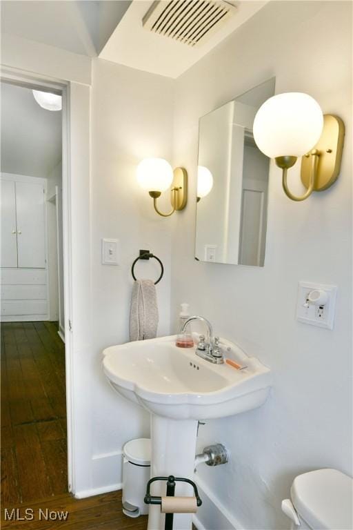 bathroom featuring hardwood / wood-style flooring and toilet